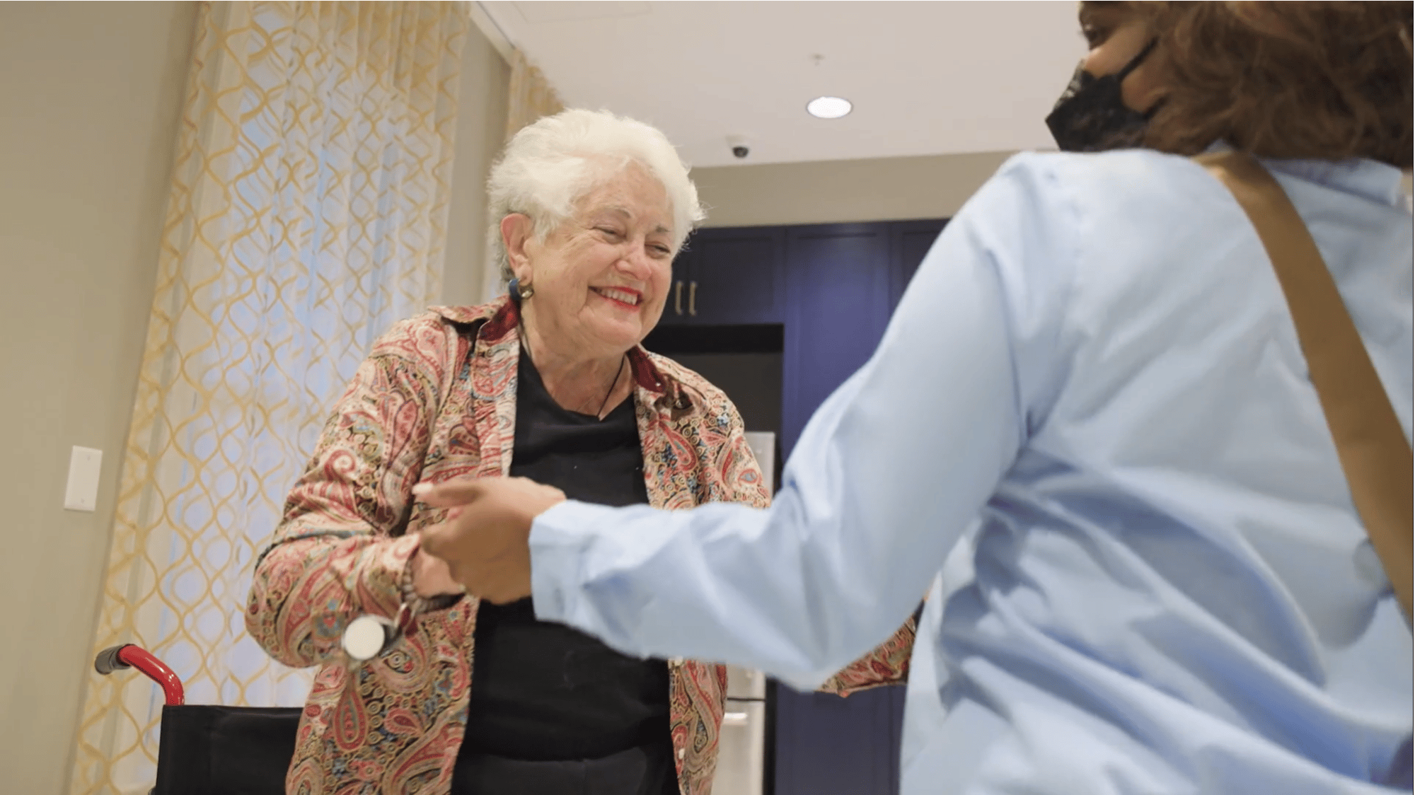 A resident and staff member share a warm handshake at Arbor Terrace Glenview senior living, reflecting the close bonds of the active senior lifestyle Glenview offers.