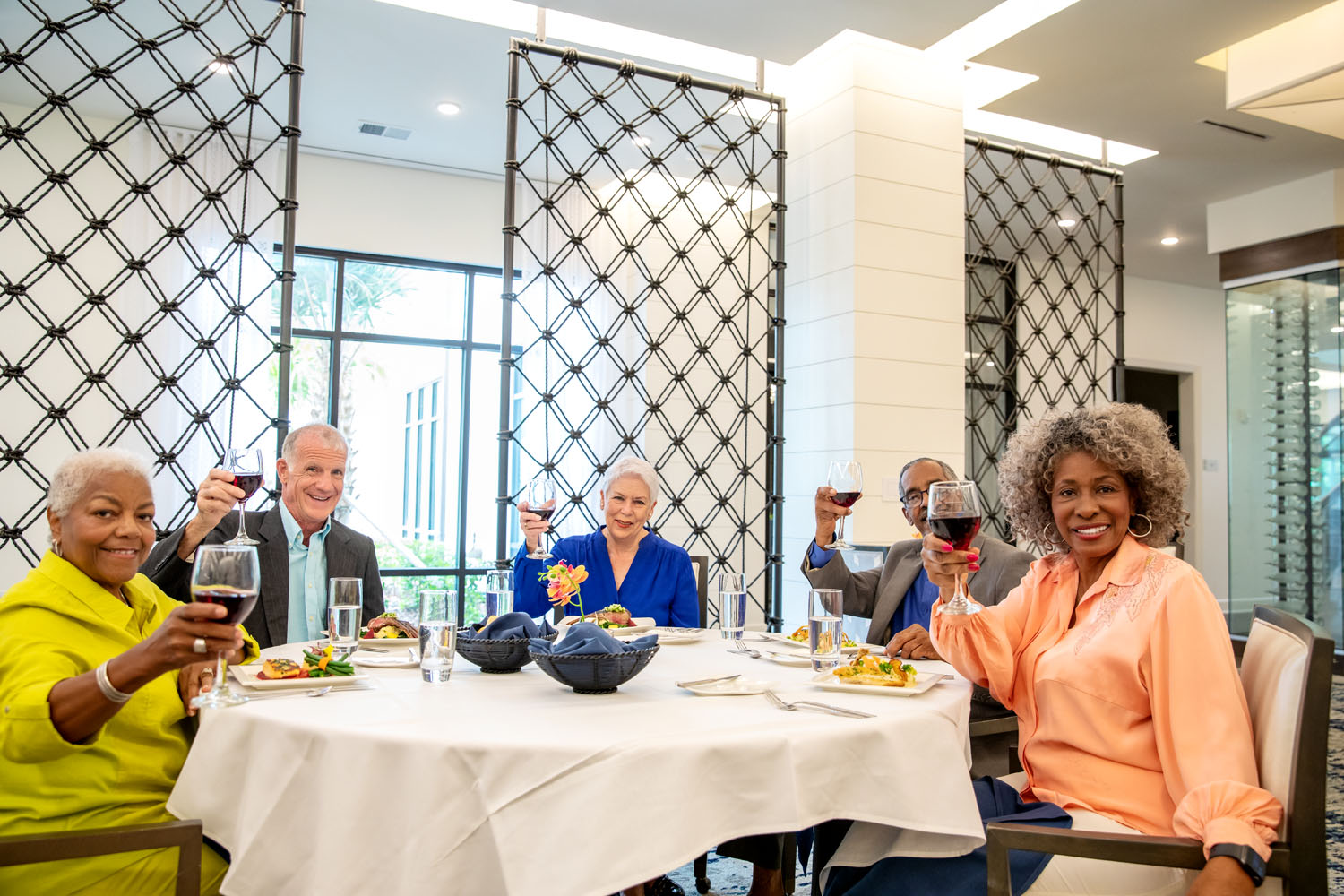 Senior citizen friends smiling holding wine glasses